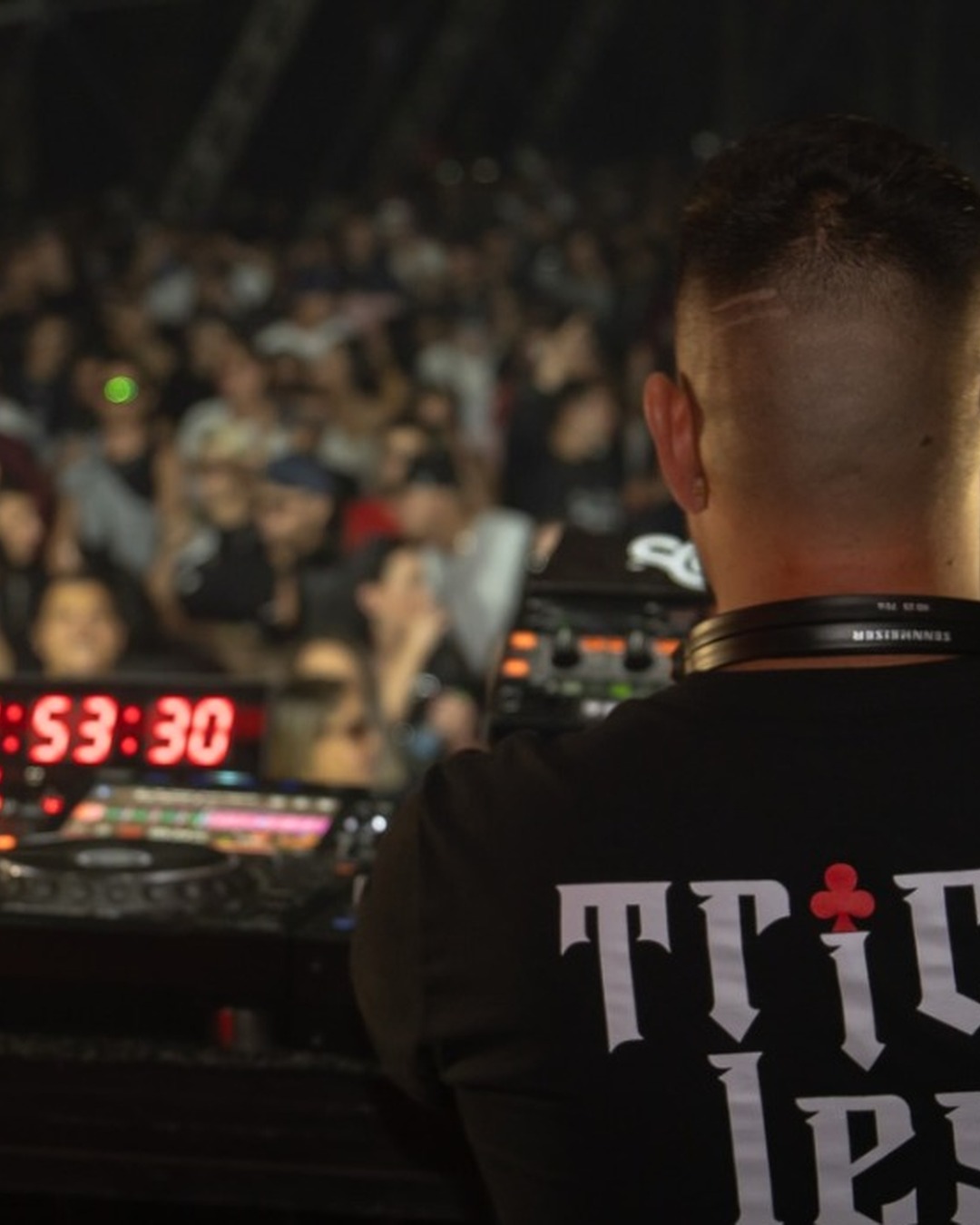 Close da camiseta Trick less na cabine, cronômetro 0:53:30 e o público.